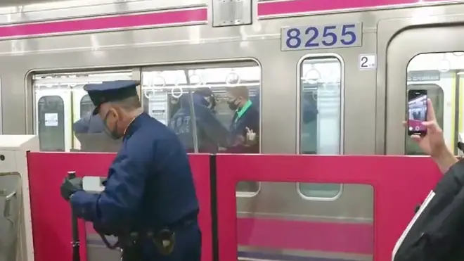 Police arrest a suspect following the attack on a Tokyo train