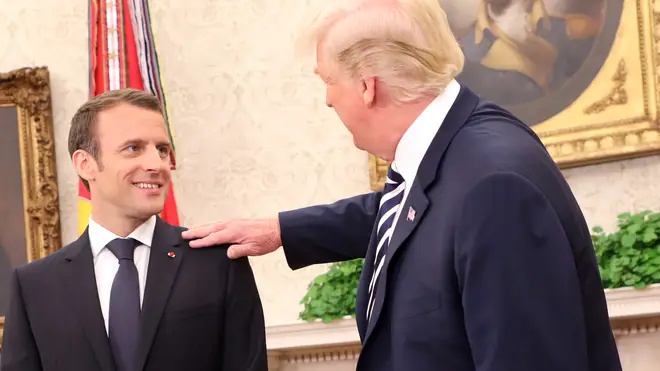 US President Donald Trump wipes "dandruff" off French President Emmanuel Macron&squot;s jacket in the Oval Office