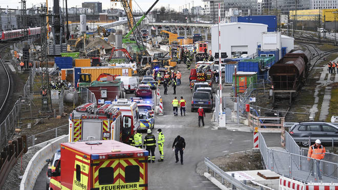 Firefighters, police officers and railway employees stand on a railway site in Munich, Germany (Sven Hoppe/dpa via AP)
