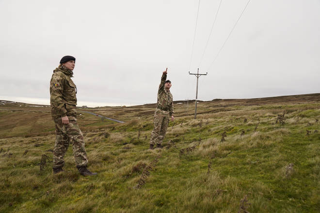 Members of the armed forces check on overhead power cables in Weardale.