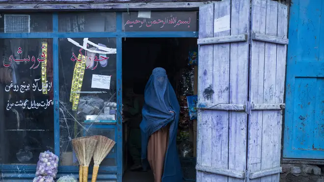 An Afghan woman wearing a burka leaves a shop in Kabul