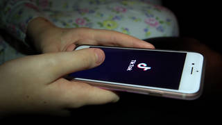 A young girl uses TikTok on a smartphone
