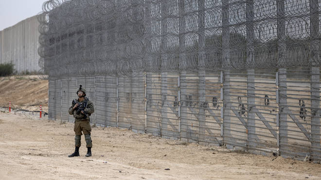 An Israeli soldier stands guard during a ceremony to open the newly completed barrier along the Israel/Gaza border