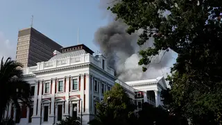 Smoke billows from the roof of a building at the South African Parliament.