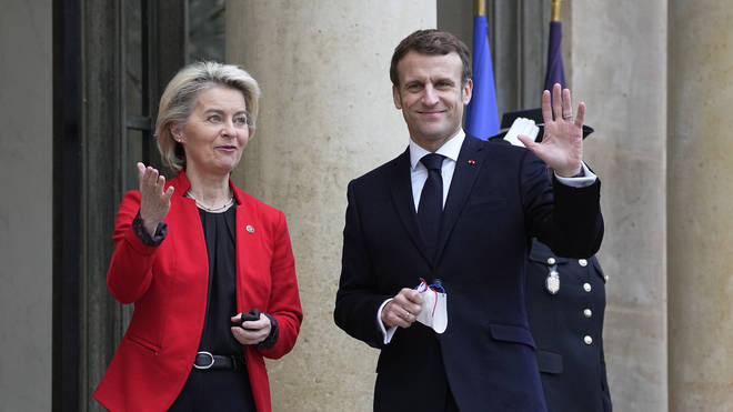 French President Emmanuel Macron waves as he greets European Commission president Ursula von der Leyen at the Elysee Palace in Paris