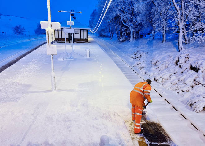 A railway worker clears snow from the platform at Rannoch Station