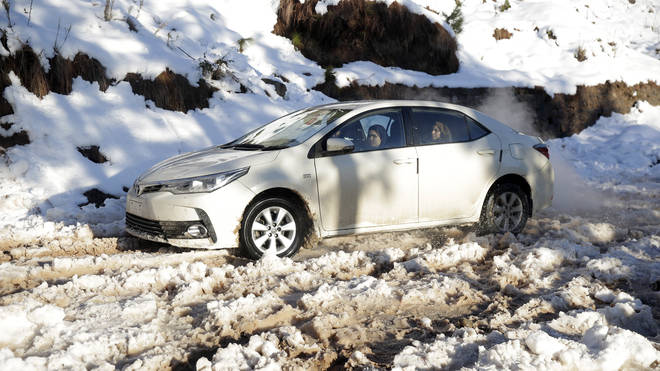 A car stranded on a snow-covered road in Murree