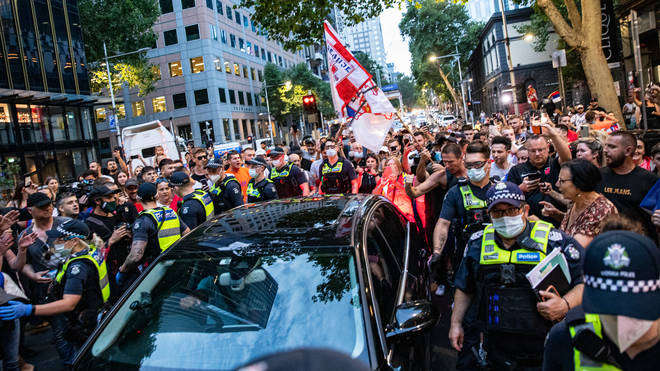 Fans mob a car in Melbourne as the legal case over Djokovic's visa carried on