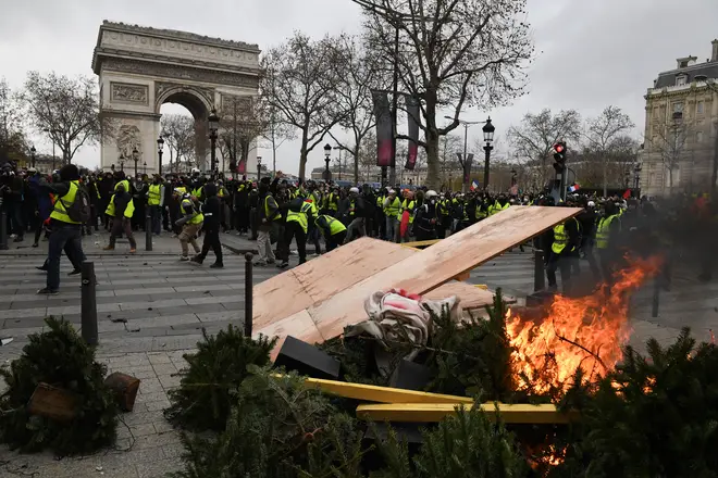 Demonstrators burn Christmas trees near the Arc de Triomphe