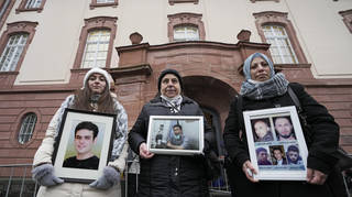 From left, Syrian women Samaa Mahmoud, Mariam Alhallak and Yasmen Almashan hold pictures of relatives who died in Syria, before the verdict in front of the court in Koblenz, Germany