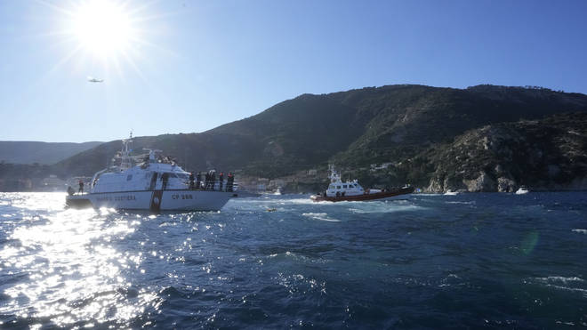Italian coast guard units stand at the spot where the Costa Concordia cruise ship capsized, during a commemoration for the victims of the ship disaster, in front of Giglio Island, Italy