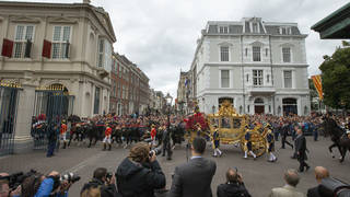 Footmen walk alongside the Golden Carriage as King Willem-Alexander and Queen Maxima arrive at Noordeinde Palace after officially opening the new parliamentary year in The Hague, Netherlands, in 2013
