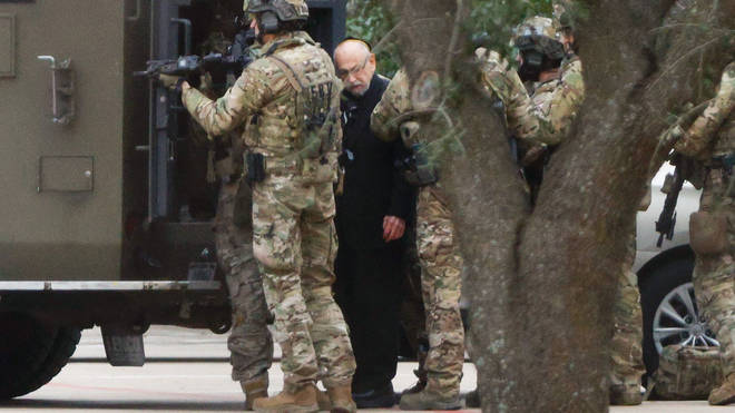 Authorities escort a hostage out of the Congregation Beth Israel synagogue in Colleyville, Texas