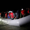 A group of migrants on an inflatable dinghy leave the coast of northern France