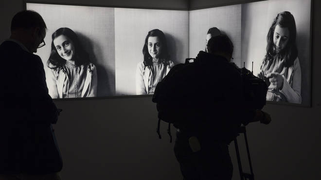 A journalist takes images of pictures of Anne Frank at the renovated Anne Frank House Museum in Amsterdam, Netherlands