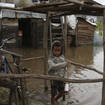 A child wades through flood water (Alexander Joe/AP)