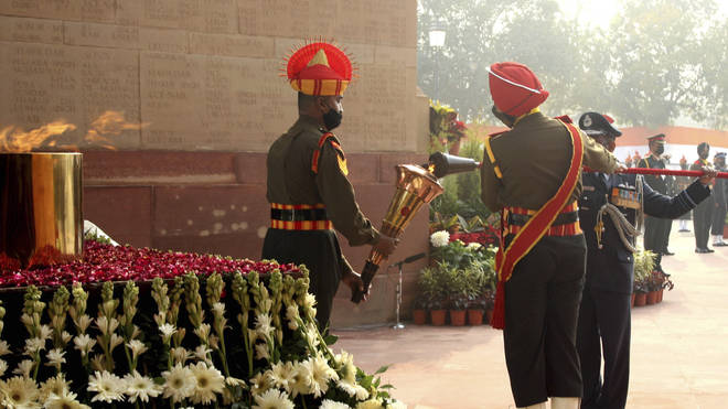 A soldier lights a torch from the eternal flame