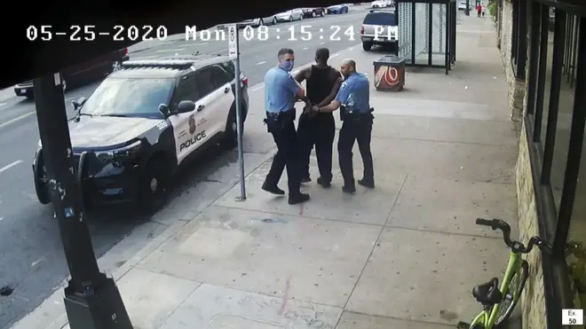 This image from video shows Minneapolis police officers Thomas Lane, left, and J Alexander Kueng, right, escorting George Floyd, centre, to a police vehicle outside Cup Foods in Minneapolis on May 25 2020
