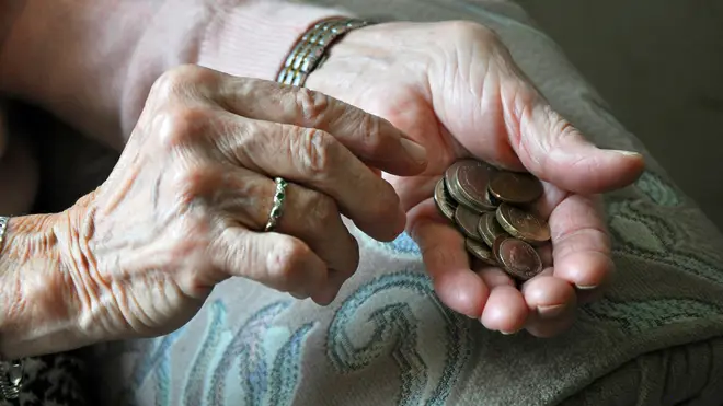 An elderly woman counting coins