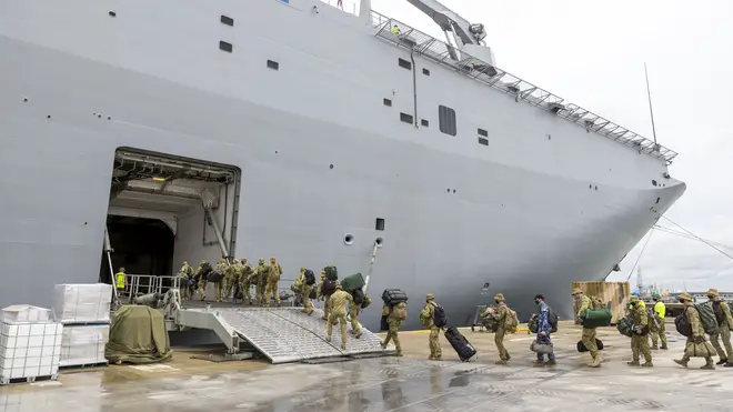 In this photo provided by the Australian Defence Force, soldiers load onto HMAS Adelaide at the Port of Brisbane
