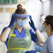 Nurses change their PPE at a Covid ward