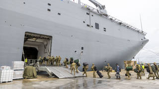 Soldiers load onto HMAS Adelaide at the Port of Brisbane before departing for Tonga last week