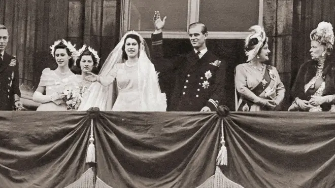 Elizabeth and Philip waving to crowds from the Buckingham Palace balcony.