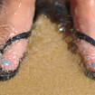 Feet in flip flops on a beach