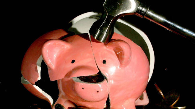 A piggy bank being smashed with a hammer
