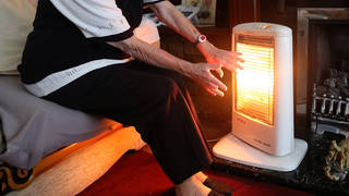 An elderly woman with an electric fire