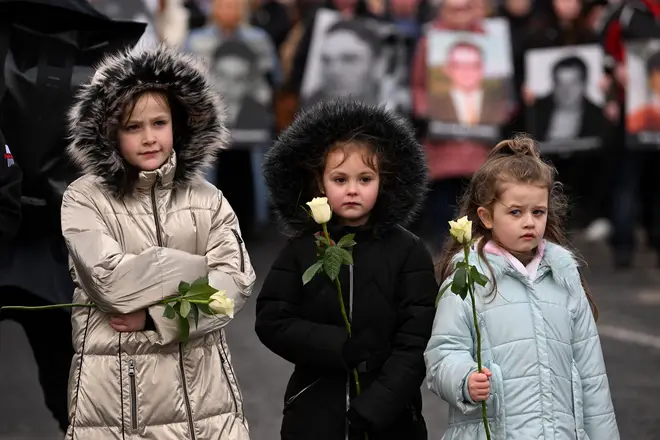 Relatives of the victims hold flowers as they participate in a Walk of Remembrance to Memorial Garden to mark the 50th Anniversary of Bloody Sunday on January 30, 2022 in Londonderry.