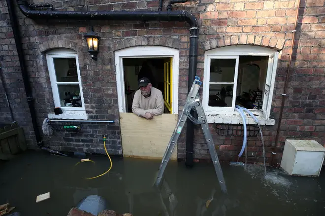 Vic Haddock uses pumps at his flooded home following high winds and wet weather in Ironbridge, Shropshire.