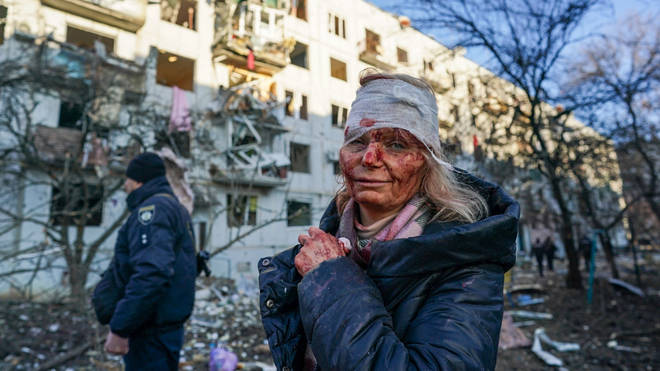 A wounded woman is seen after an airstrike damaged an apartment complex in city of Chuhuiv