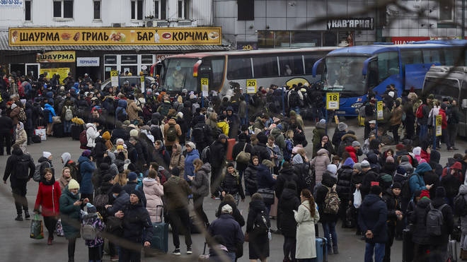 People wait for buses at a bus station as they attempt to evacuateKiev