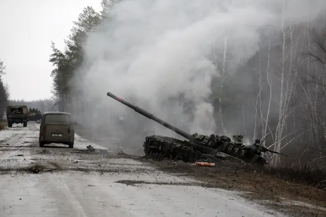 Smoke rises from a Russian tank destroyed by the Ukrainian forces on the side of a road in Luhansk region