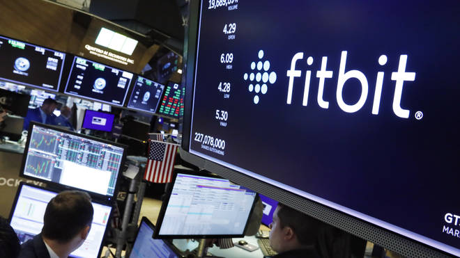 The logo for Fitbit appears above a trading post on the floor of the New York Stock Exchange
