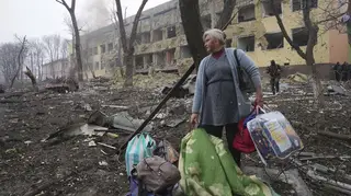 A woman walks outside a maternity hospital that was damaged by shelling in Mariupol, Ukraine