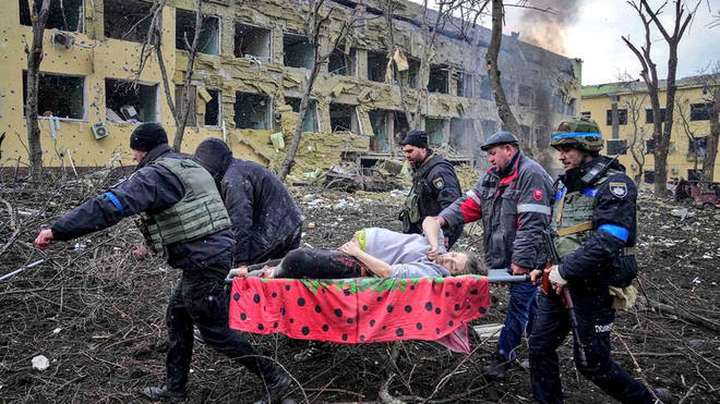 The woman was pictured being carried from the wreckage in Mariupol