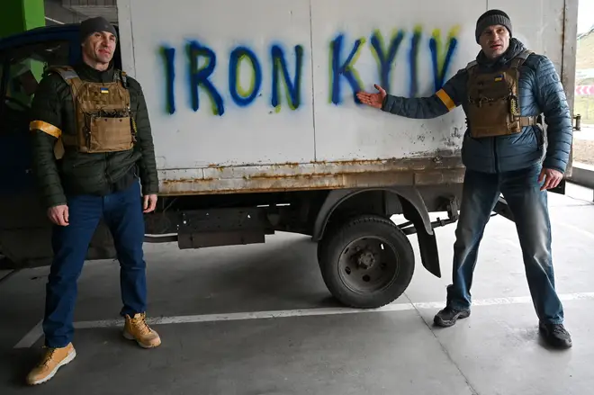 The Klitschkos point to an Iron Kyiv sign painted on a truck in the city