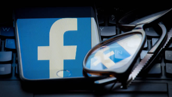 The Facebook logo on a smartphone screen reflected in a pair of glasses