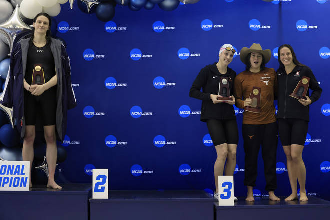 Lia Thomas (L) of the University of Pennsylvania stands on the podium after winning the 500-yard freestyle as other medalists (L-R) Emma Weyant, Erica Sullivan and Brooke Forde, pose together in protest