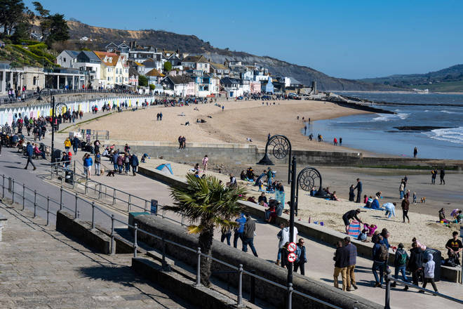 Visitors and locals flock to the beach to soak up the hot sunshine at Lyme Regis in Dorset