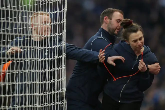 A 'Just Stop Oil' protestor is prevented from putting her cable tie on the goal net during the Premier League match between Tottenham Hotspur and West Ham United.