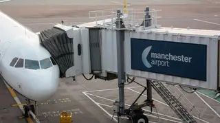 A passenger plane connected to a jetbridge at Manchester Airport