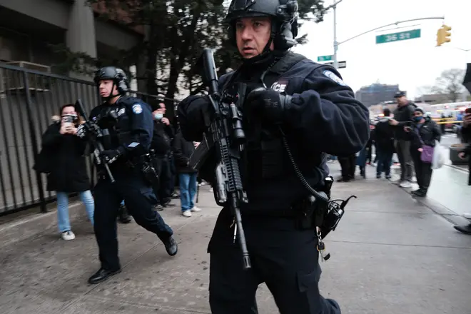 Police armed with assault rifles race to the scene of the shooting