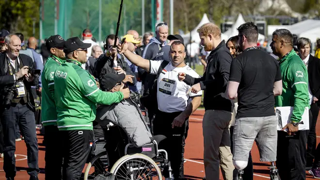 Prince Harry and Meghan Markle talk to participants during the athletics section of the fifth edition of the Invictus Games