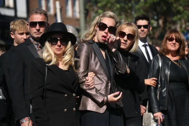 Wife of Tom Parker, Kelsey Parker (C), follows a horse-drawn hearse during a procession through Orpington