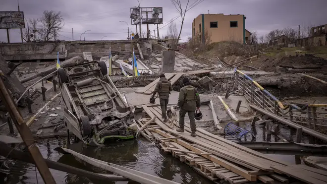 Ukrainian soldiers walk on a destroyed bridge in Irpin, on the outskirts of Kyiv, on Wednesday April 20 2022