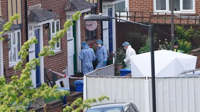 Police officers in forensic suits enter a house in Bermondsey, south-east London after three women and a man were stabbed to death