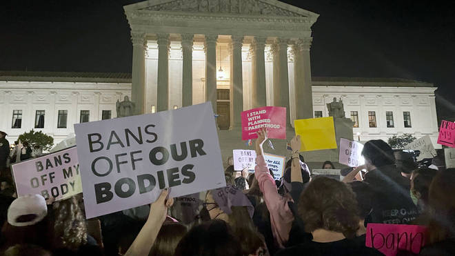 A crowd of people gather outside the Supreme Court on Monday night